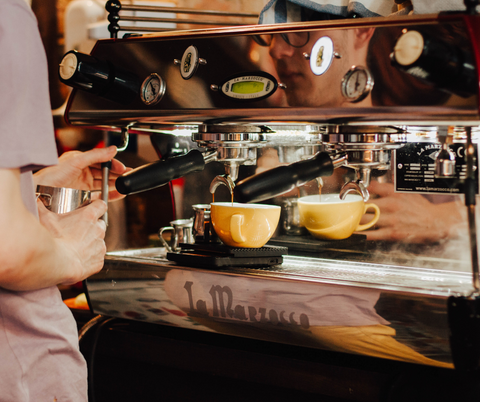 Barista expertly pouring SplitShot reduced-caffeine coffee into a cup, showcasing the craftsmanship behind every brew.